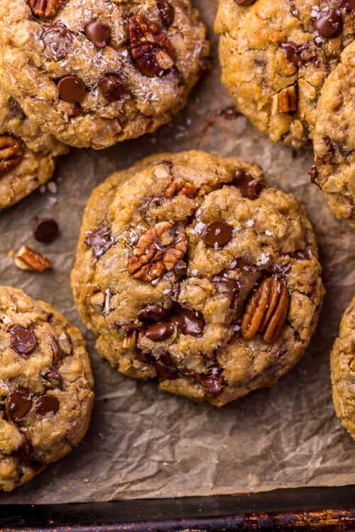 Cowboy cookies on a parchment paper lined baking sheet.